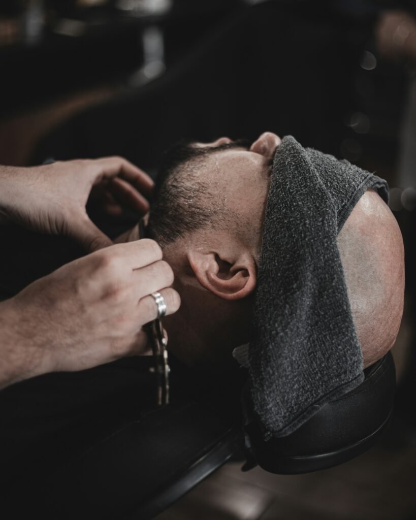 a man getting his hair cut by a barber